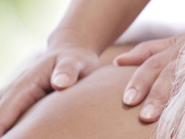 Rückenmassage: Hände auf dem Rücken einer liegenden Person